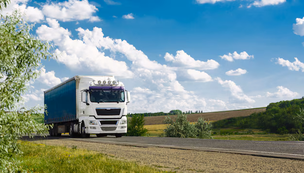 A commercial truck hauling freight down an open highway under a clear sky in the tightening 2026 market